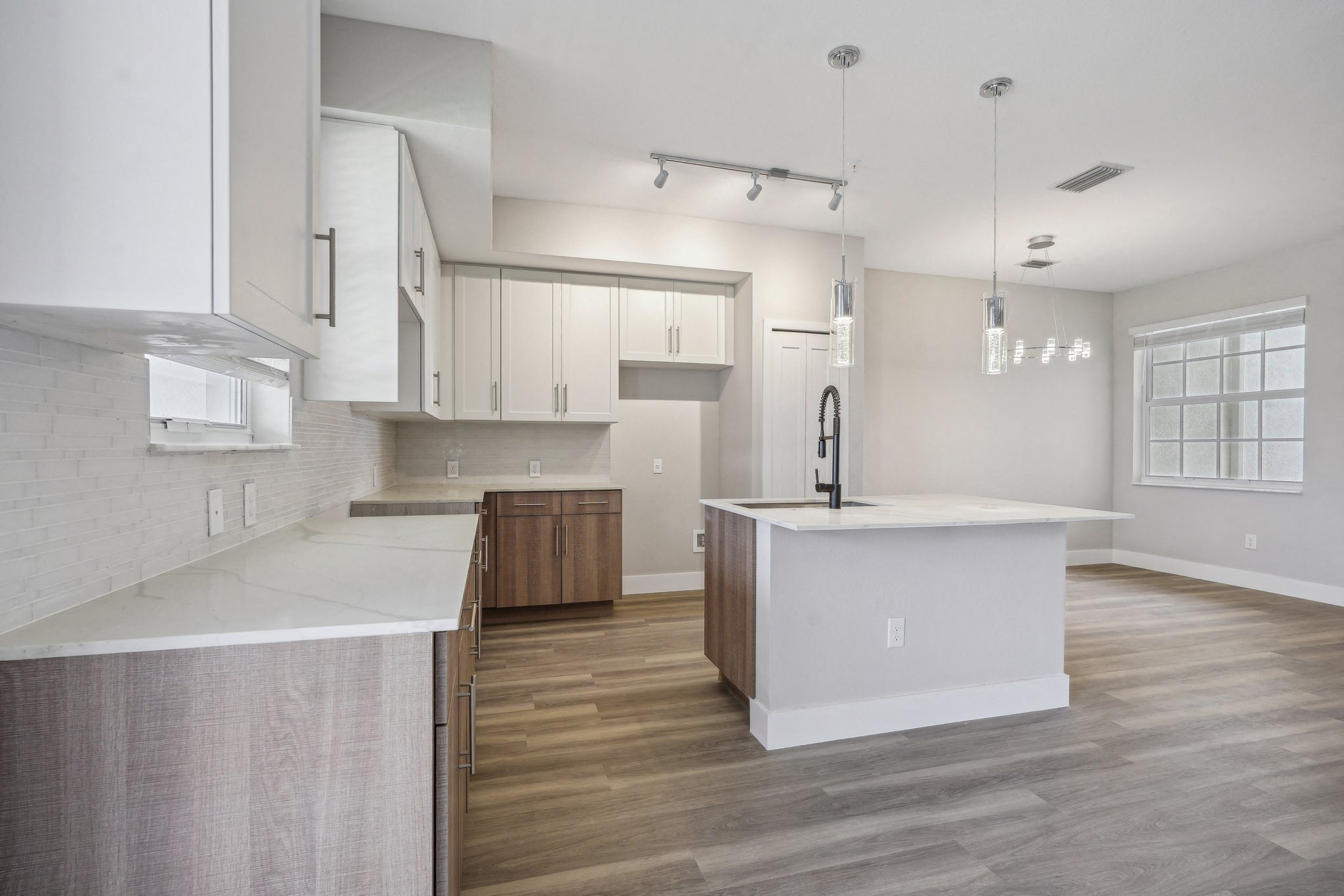 a white kitchen with a large island in the middle of it